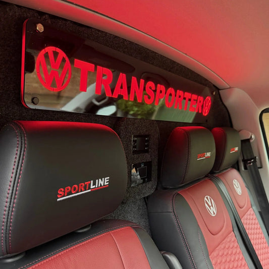 VW Transporter Bulkhead Sign 900x150mm, glowing red, mounted on a carpeted bulkhead with control panels, enhancing the sporty interior of a VW Transporter cab.