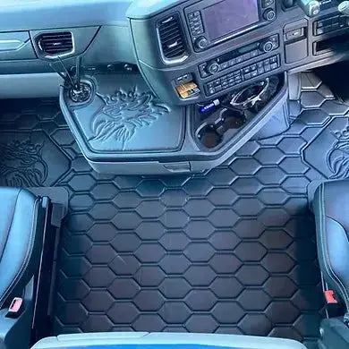 Scania Next Gen Truck Floor Mats with hex pattern and lion emblems in truck cab, featuring custom fit around center console and seats.