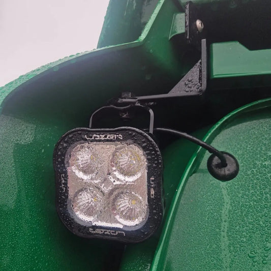 Close-up of a wet LED light pod on a bracket, showcasing Scania Next Gen Reduced Wind Kit Work Light Mounts, suitable for mounting work lights without extra drilling.