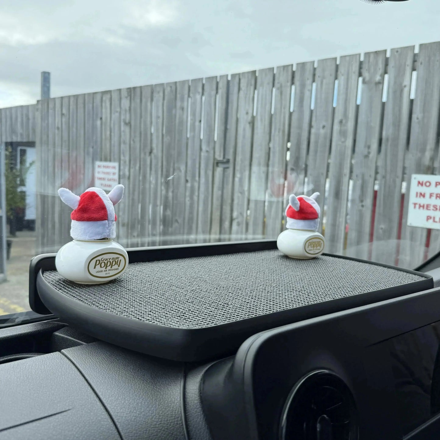 MAN TGE LED Dash Table (2017-On) with non-slip tray holding two Santa-hat-topped Grace Mate Poppy air fresheners, visible through vehicle windshield.