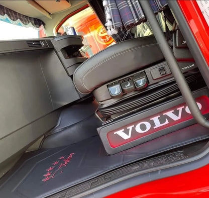 Volvo FH/FM Truck Black LED Seat Bases visible in cab, paired with a black leather air-suspension seat, custom floor mat, and plaid curtain.