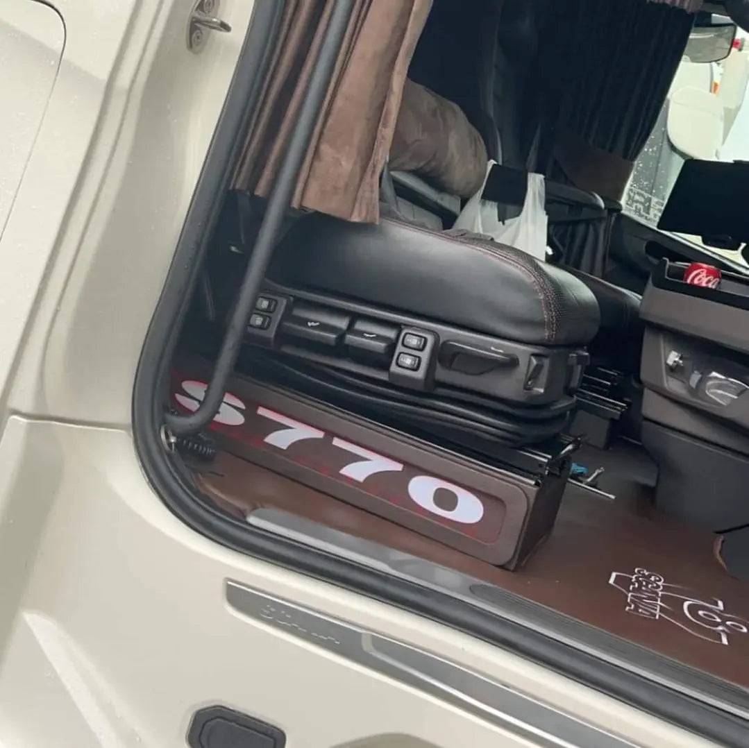 Interior view of a semi-truck cab featuring Scania Next Gen S650 LED Seat Bases Black With RED LED, adjustable driver's seat, and visible Mercedes-Benz badge.
