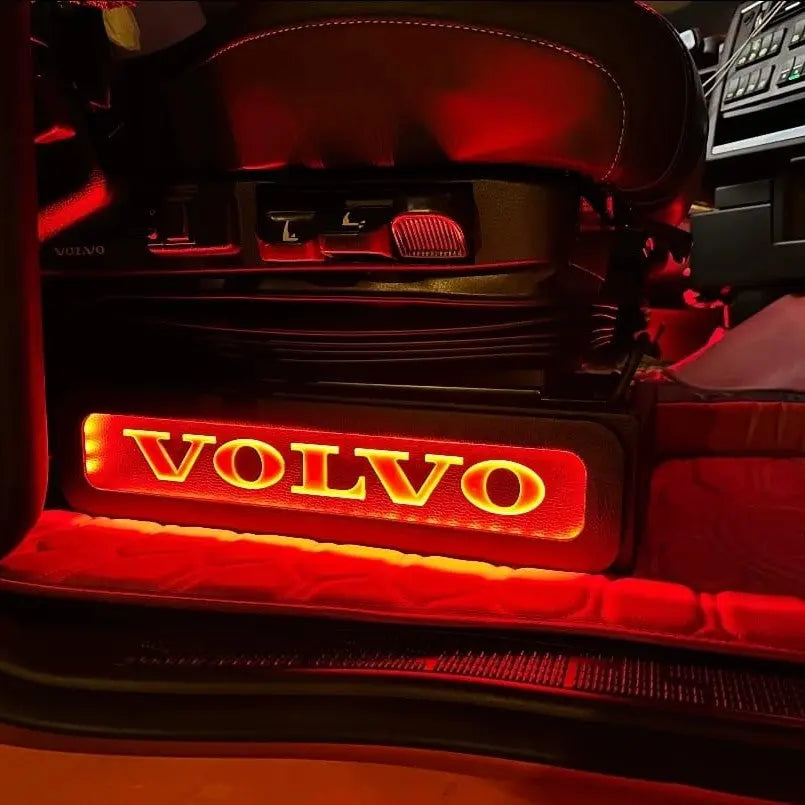 Close-up of Volvo FH/FM Truck Black LED Seat Bases with red LED lighting, showing illuminated VOLVO logo and seat adjustment controls in a truck cabin.