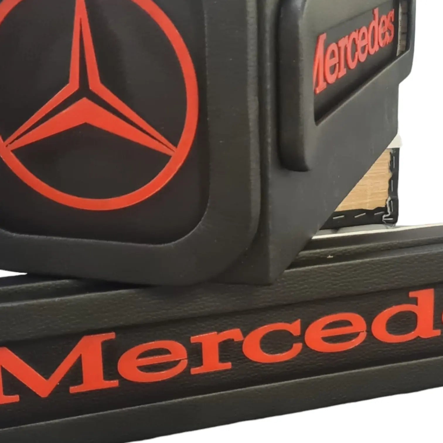 Close-up of a black Mercedes-branded armrest organizer with red logo, designed for Mercedes MP4/5 Truck LED Seat Bases, showcasing faux-leather finish.