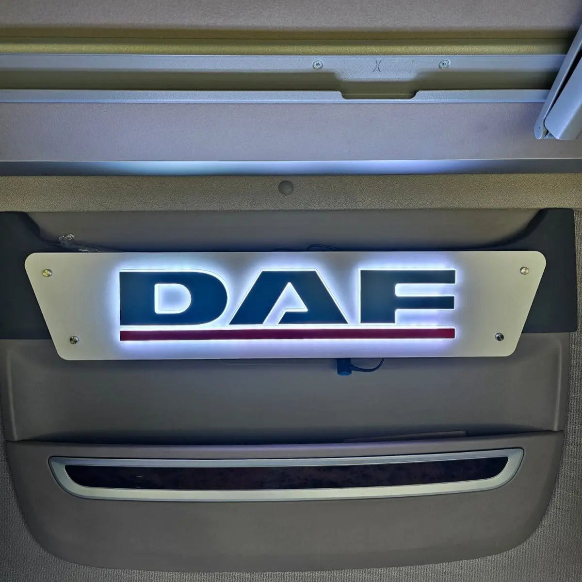 DAF 3D Truck Light Board illuminated with DAF and red underline, mounted inside a truck cab, showcasing a stylish, customizable RGB LED display for enhanced interior aesthetics.