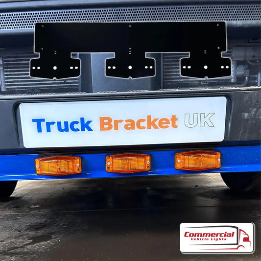 Double Burner Number Plate Mount on truck bumper, featuring blue cross-member with amber lights. Placard: Truck Bracket UK, logo: Commercial Vehicle Lights.