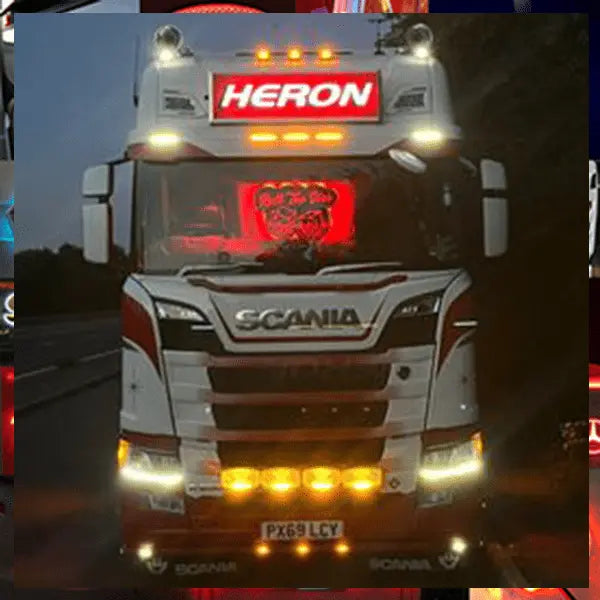 Scania truck with HERON LED headboard, part number DSH105x30STDW, featuring white LED illumination and multiple auxiliary lights, UK license PX69 LCY visible.