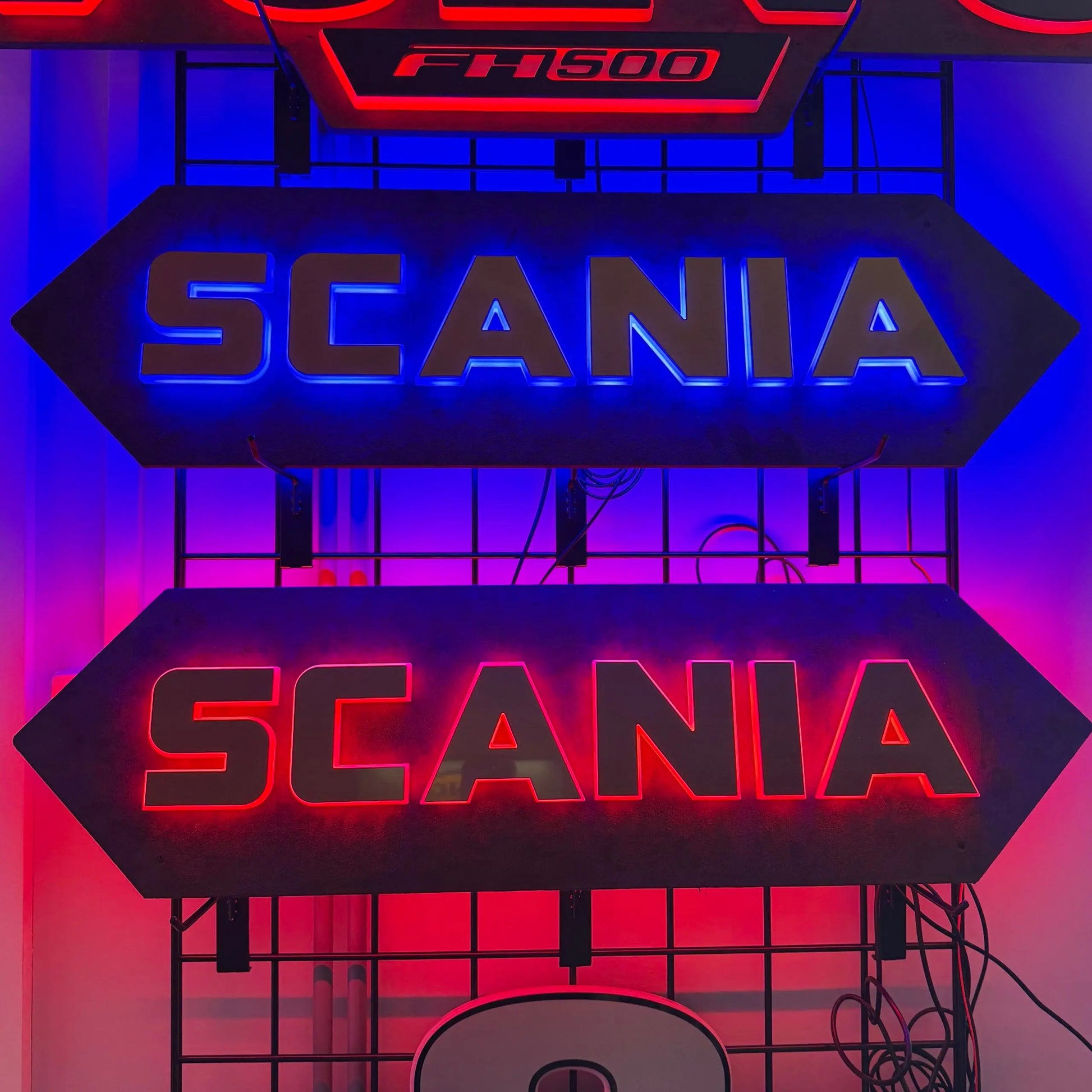 Scania Infill Panel LED Truck Light Board by TLD 24 Volt, featuring illuminated SCANIA and FH500 signs on a metal display rack.