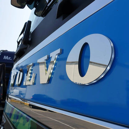 Volvo Grille Badge Led Back-Lit on a blue Volvo truck, featuring polished chrome letters. Reflects surroundings, suitable for 24V vehicles, shockproof and waterproof.