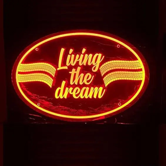 Glowing neon sign 'Living the dream' in cursive, framed in oval, with wavy lines, mounted on a Plexi Glass Light Board for vehicle interiors.