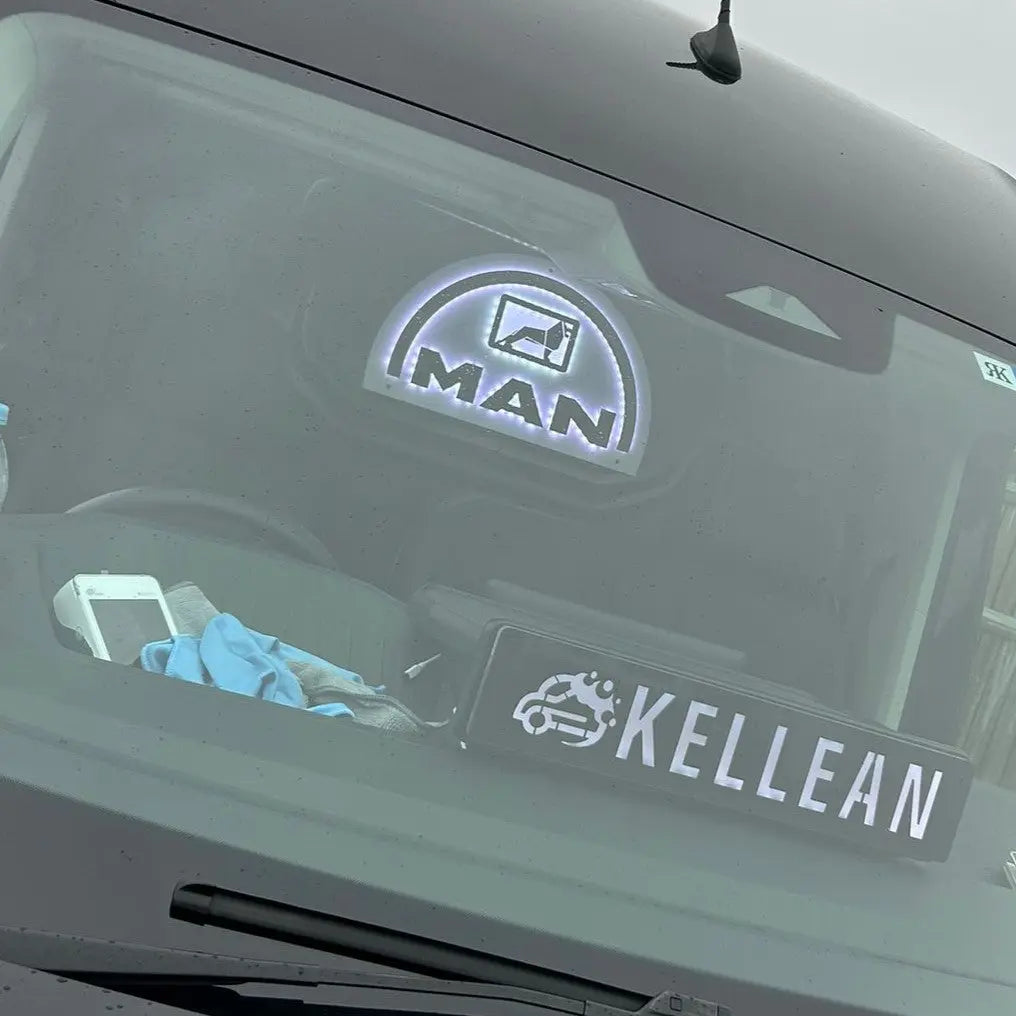 MAN 3D Truck Light Board inside truck cab, featuring the MAN logo on glass, alongside a KELLEAN sign, microfiber cloth, and a small device.
