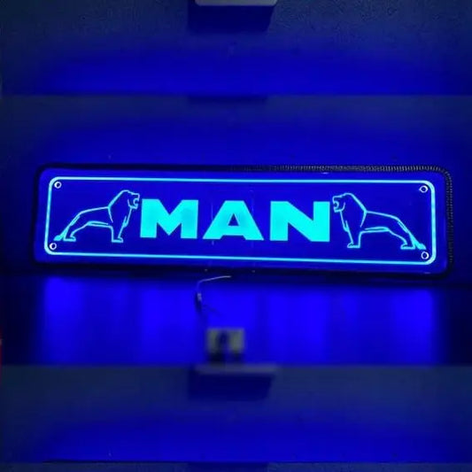 Blue neon MAN Plexi Glass Sign with stylized lions, mounted on wall with visible wires; back-lit, suitable for 12/24V vehicles, enhancing truck cabin style.