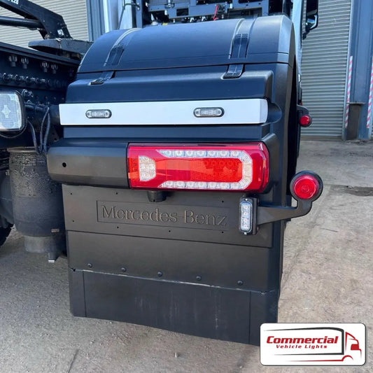 Mercedes Actros Rear Wing Rail Covers shown next to a Mercedes-Benz tractor unit's rear lights, highlighting their sleek fit and durable stainless steel construction.