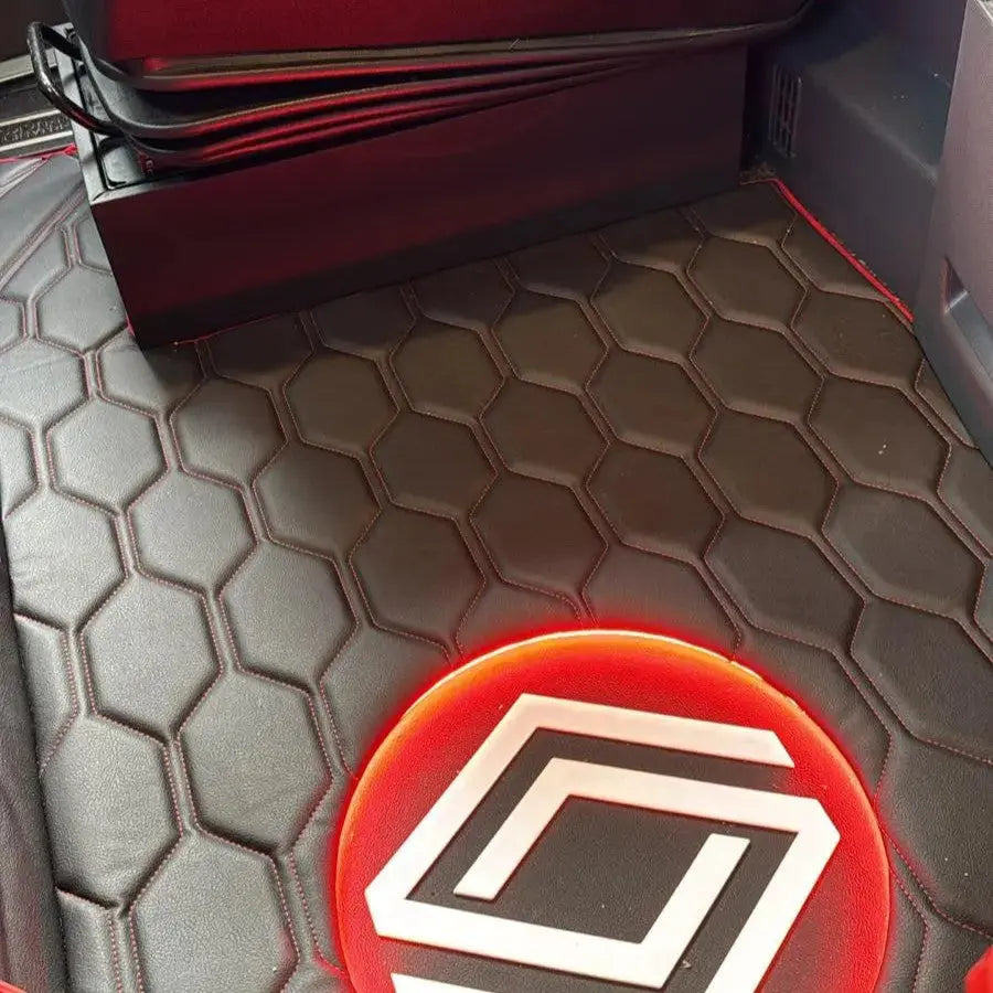 Renault T Range Truck LED Seat Bases feature a hexagon-quilted leather floor mat with red stitching and a red-glowing LED projecting a stylized logo.
