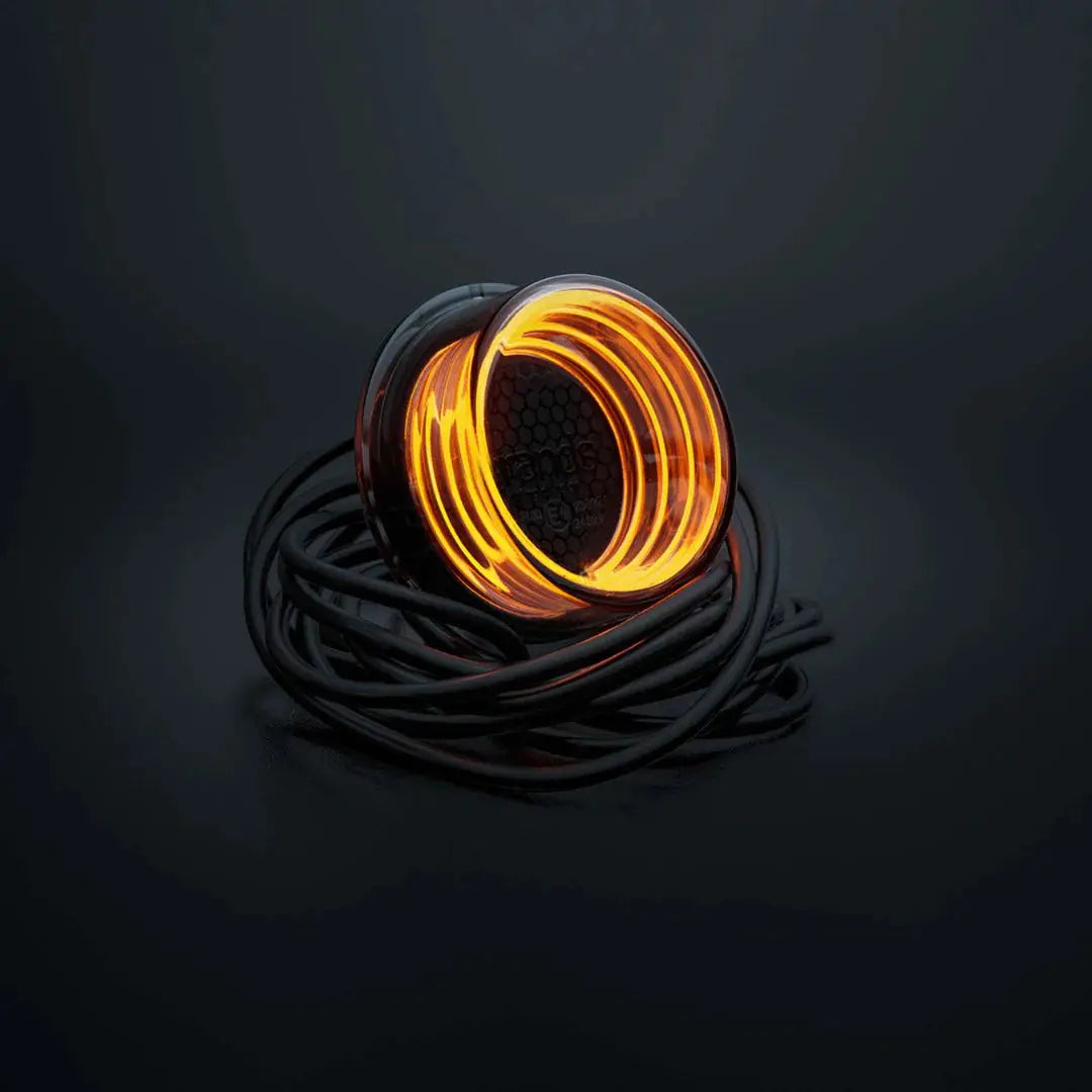 Strands FOR9T Geo Outline Marker Lights featuring a glowing coil of flexible LED wire wound around its black power lead, displayed on a dark surface.