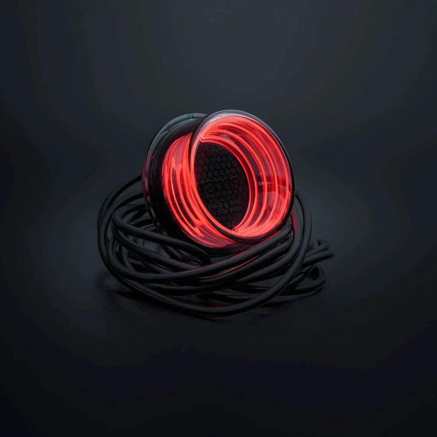 Strands FOR9T Geo Outline Marker Lights: A spool of glowing red LED rope lighting with translucent housing, coiled atop a dark surface, black power cable attached.