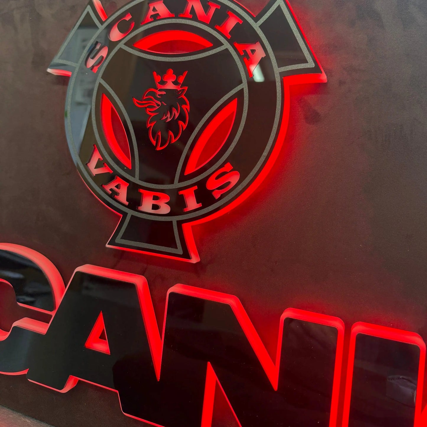 Scania Infill Panel LED Truck Light Board by TLD 24 Volt featuring a crowned griffin emblem, back-lit with red LEDs on a dark grey Alcantara-wrapped panel.