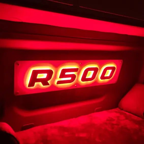 Illuminated R500 badge on a bulkhead, showcasing the R/S Series Truck Light Board, Scania compatible, with stylish design and LED RGB technology for truck interiors.