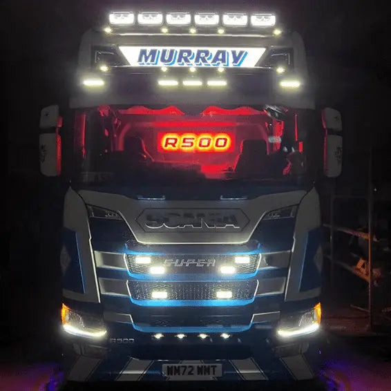 Scania R500 “Super” at night, showcasing the R/S Series Truck Light Board, fitted with LED lights around its grille, bumper, and roof.