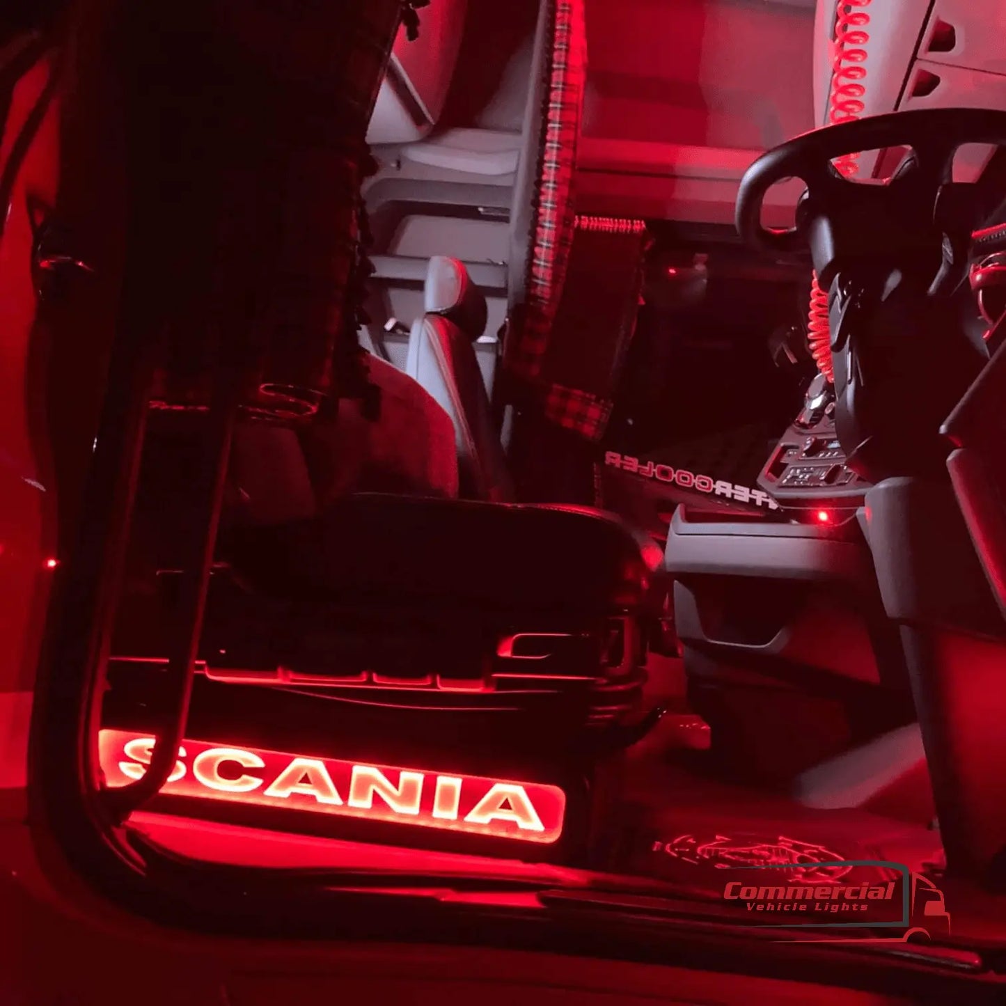 Scania Next Gen S650 LED Seat Bases Black With RED LED in driver's cab, showing illuminated sill-plate, steering wheel, and plaid curtains.