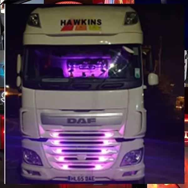 Front view of a white DAF truck with HAWKINS badge and purple LED lights, featuring the TRUCKER GIRL BULKHEAD MIRROR LIGHTBOARD 1000x250mm mounted inside.