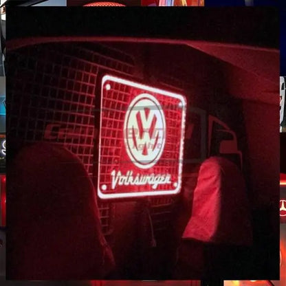 Volkswagen Caddy Led Lightboard 400x300 mm displayed in a van interior, glowing VW logo and Volkswagen text, fitted behind seats on metal mesh partition.