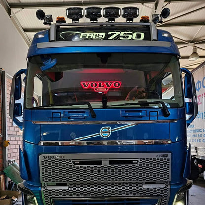 Scania Infill Panel LED Truck Light Board by TLD, mounted on a blue Volvo FH16 truck, featuring a sleek design with roof spotlights in a workshop setting.