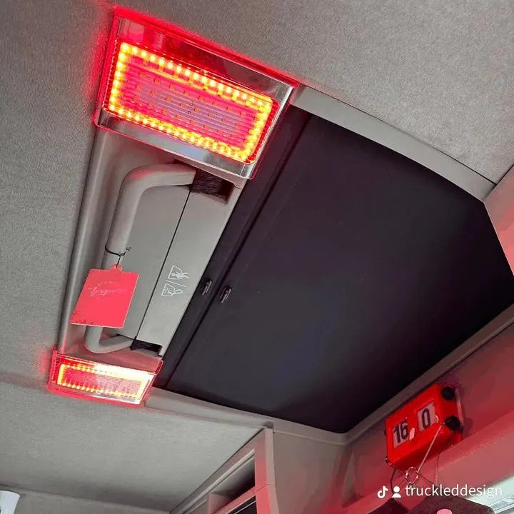 Volvo FM/FH Version 4 Interior Lights: Overhead view with two red LED floodlights, manual sunroof, and custom gauge, showcasing LED retrofit for truck cabins.
