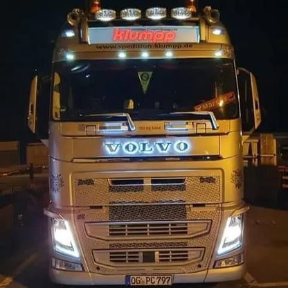 Volvo FH truck at night with illuminated klumpp sign showcasing the Volvo Grille Badge LED Back-Lit, highlighting its compatibility with 24V vehicles.
