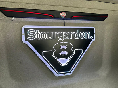 Wall-mounted MAN 3D Truck Light Board with backlit Stourgarden. text, LED-outlined stylized 8 and bold V shape, featuring an illuminated design.